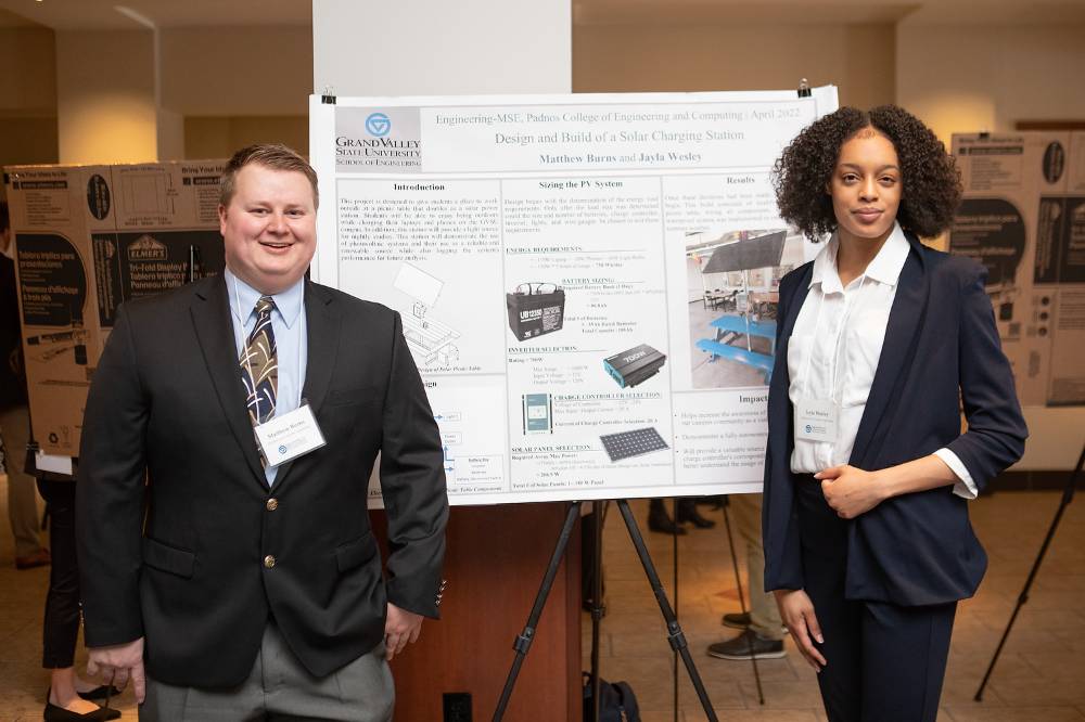 Electrical and computer engineering graduate students, Matthew Burns (left) and Jayla Wesley (right), standing in front of their poster.